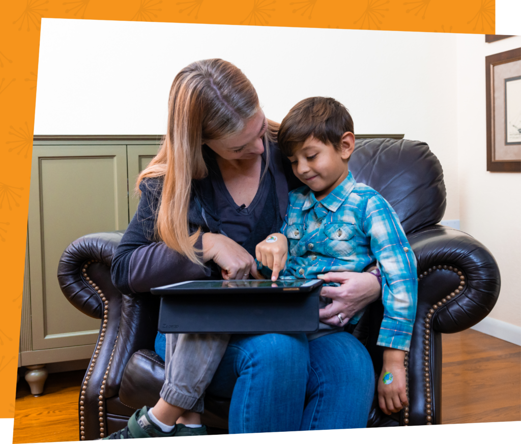 Child sitting on his mom's lap going over a Funnix learning lesson together in a family living room.